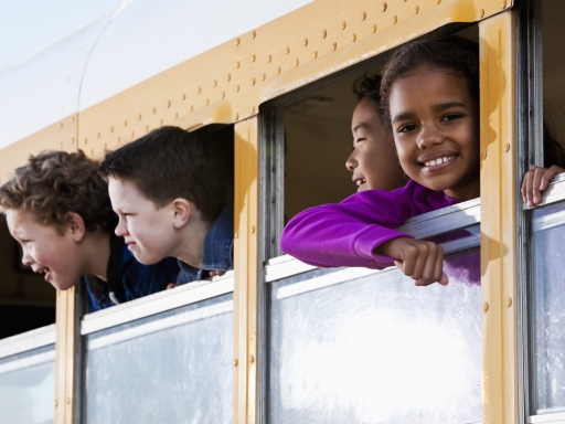 Smiling students in a school bus.